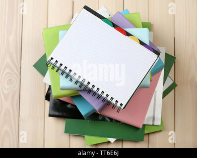 Notebook auf Stapel Bücher und Zeitschriften auf hölzernen Hintergrund Stockfoto