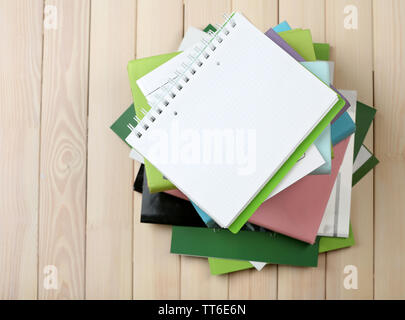 Notebook auf Stapel Bücher und Zeitschriften auf hölzernen Hintergrund Stockfoto