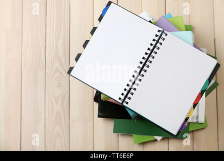 Notebook auf Stapel Bücher und Zeitschriften auf hölzernen Hintergrund Stockfoto