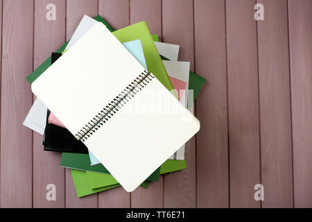 Notebook auf Stapel Bücher und Zeitschriften auf hölzernen Hintergrund Stockfoto