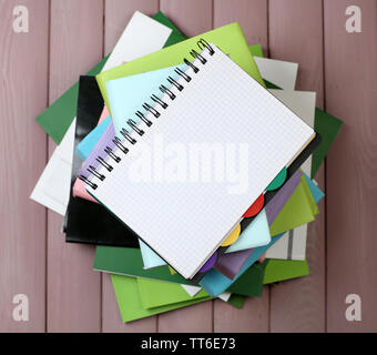 Notebook auf Stapel Bücher und Zeitschriften auf hölzernen Hintergrund Stockfoto