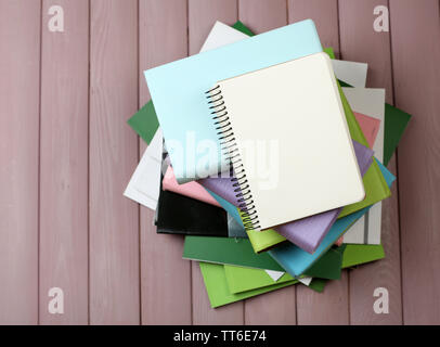 Notebook auf Stapel Bücher und Zeitschriften auf hölzernen Hintergrund Stockfoto