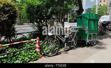 Tokyo, Japan - 13. Mai 2019: Eine Lieferung Fahrrad mit einem grünen Warenkorb dahinter befestigt, am Straßenrand geparkt. Wie Fahrradkurier ist in Japan. Stockfoto