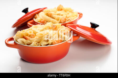 Pasta mit Garnelen und Käse in Keramik Topf, isoliert auf weißem Stockfoto