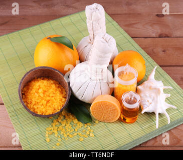 Spa noch Leben mit compress Kugeln und Kokosnussschalen auf Farbe Bambus matte und Holz- Hintergrund Stockfoto