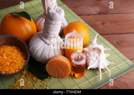 Spa noch Leben mit compress Kugeln und Kokosnussschalen auf Farbe Bambus matte und Holz- Hintergrund Stockfoto