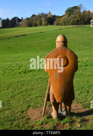 Die Schlacht von hasting Schlacht mit Battle Abbey im Hintergrund und in voller Größe aus Holz geschnitzten Soldaten im Vordergrund. Stockfoto