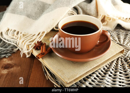 Tasse Kaffee ein Buch in der Nähe von Plaid auf hölzernen Tisch Hintergrund Stockfoto