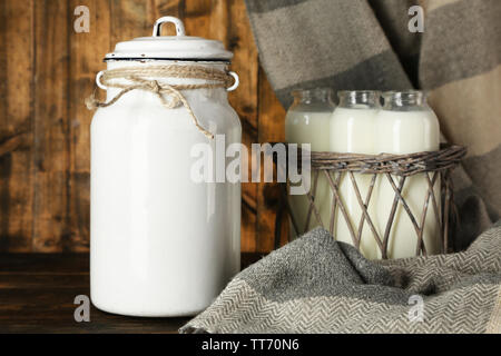 Milch- und Glasflaschen auf rustikalen hölzernen Hintergrund Stockfoto