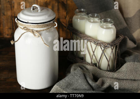 Milch- und Glasflaschen auf rustikalen hölzernen Hintergrund Stockfoto