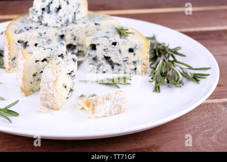 Blauschimmelkäse mit Zweige Rosmarin auf Holzbrett Hintergrund Stockfoto