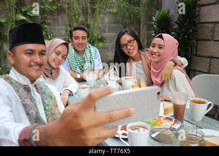 Eine Gruppe von Freunden, die selfie am Tisch speisen während des Ramadan Feier Stockfoto