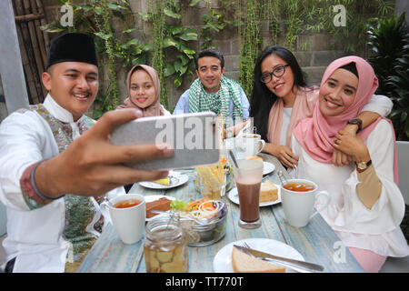 Eine Gruppe von Freunden, die selfie am Tisch speisen während des Ramadan Feier Stockfoto