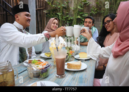 Eine Gruppe von Freunden in Kaffee Toast am Tisch speisen während des Ramadan Feier Stockfoto