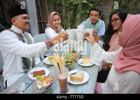 Eine Gruppe von Freunden in Kaffee Toast am Tisch speisen während des Ramadan Feier Stockfoto