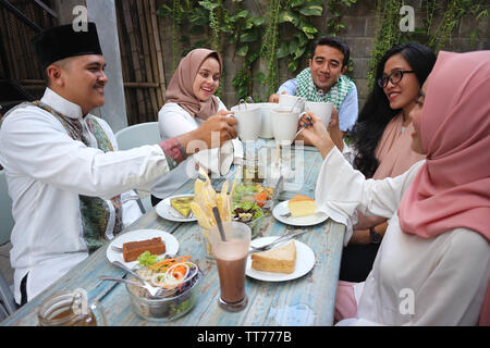 Eine Gruppe von Freunden in Kaffee Toast am Tisch speisen während des Ramadan Feier Stockfoto