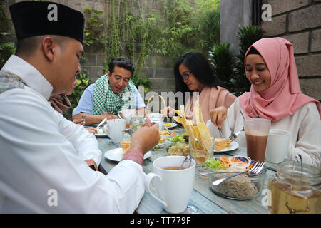 Gruppe der glückliche junge muslimische Abendessen im Freien während des Ramadan Feier Stockfoto