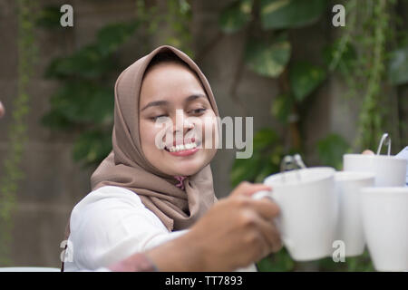 Hijab Frauen Tee Toast am Tisch speisen während des Ramadan Feier Stockfoto