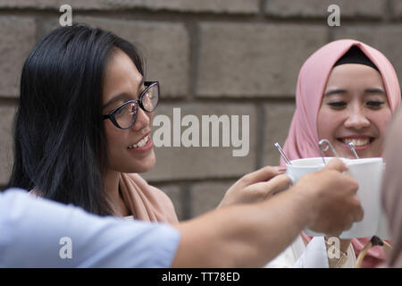 Eine Gruppe von Freunden in Kaffee Toast am Tisch speisen während des Ramadan Feier Stockfoto