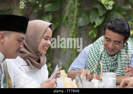 Gruppe der glückliche junge muslimische Abendessen im Freien während des Ramadan Feier Stockfoto