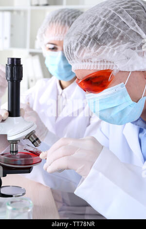 Wissenschaftlern und Wissenschaftlerinnen mit Mikroskop im Labor Stockfoto