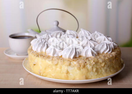 Leckere hausgemachte meringue Kuchen und einer Tasse Tee auf Holztisch, auf hellen Hintergrund Stockfoto