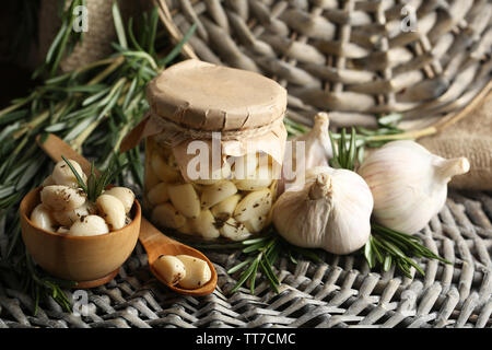 Konserven Knoblauch in Glas und Rosmarin Zweige Wicker matte Hintergrund Stockfoto