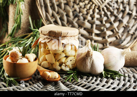 Konserven Knoblauch in Glas und Rosmarin Zweige Wicker matte Hintergrund Stockfoto