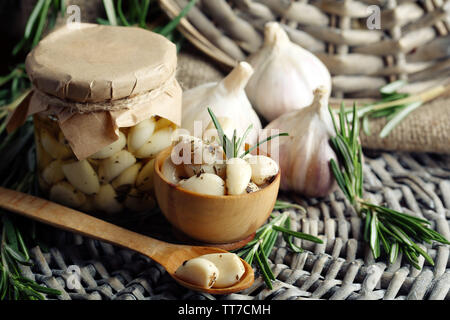 Konserven Knoblauch in Glas und Rosmarin Zweige Wicker matte Hintergrund Stockfoto