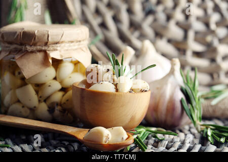 Konserven Knoblauch in Glas und Rosmarin Zweige Wicker matte Hintergrund Stockfoto