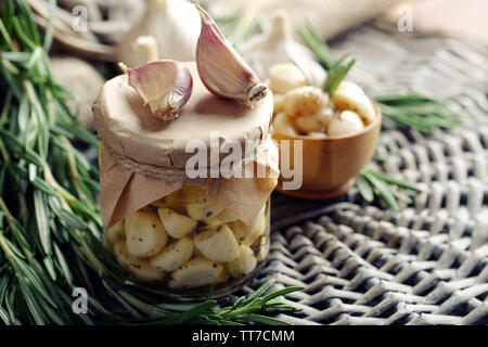 Konserven Knoblauch in Glas und Rosmarin Zweige Wicker matte Hintergrund Stockfoto