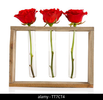 Drei frische Rosen in Glasvase und stand aus Holz isoliert auf weißem Stockfoto