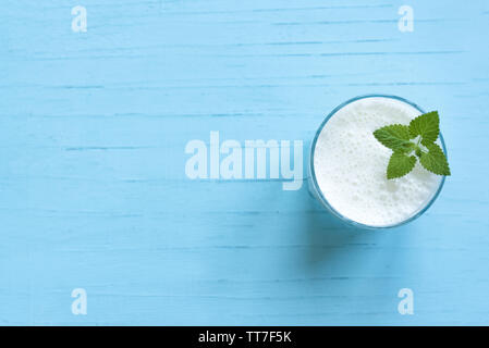 Joghurt Drink (ayran, Kefir, Lassi) im Glas - gesunde Sommer erfrischenden kalten Getränk auf Blau, kopieren. Stockfoto