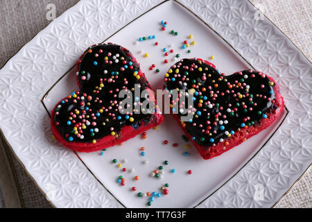 Cookies in Form von Herzen auf dem Teller und Servietten Hintergrund Stockfoto