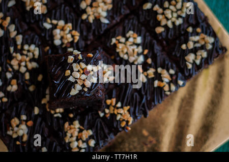 Schokoladenkuchen Schokoladenkuchen Quadrate Beträufelt mit Schokolade Nutella und Walnüsse. Detailansicht, selektiver Fokus Stockfoto