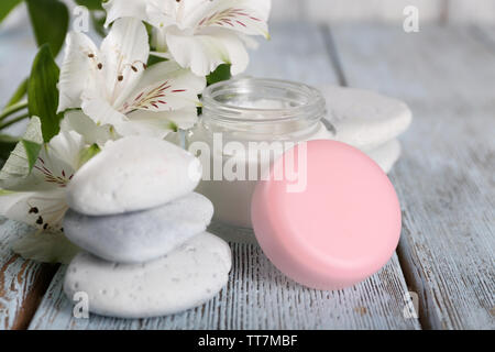 Kosmetische Creme mit Blumen und spa Steine auf Holz- Hintergrund Stockfoto