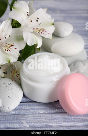 Kosmetische Creme mit Blumen und spa Steine auf Holz- Hintergrund Stockfoto