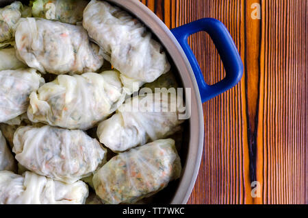 Kohlrouladen oder Dolma. Gefüllte Kohlblätter mit Hackfleisch, Reis, Gemüse und Kräuter in der Kasserolle. Auf rustikalen Holztisch isoliert, Kopie Raum Stockfoto