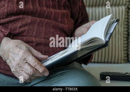 Closeup faltigen Hände einer Person, die ein Buch Stockfoto