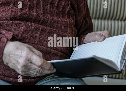 Closeup faltigen Hände einer Person, die ein Buch Stockfoto