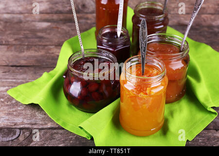 Gläser leckere Marmelade mit Serviette auf Holz- Hintergrund Stockfoto