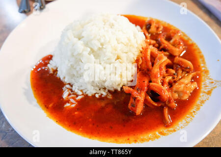 Tintenfischringe gebraten Curry mit Reis auf weiße Platte - asiatische Lebensmittel rühren Stockfoto