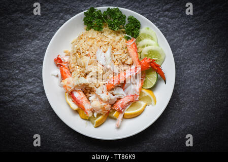 Gebratener Reis mit Krabben Fleisch ei Zitrone und Gurke auf weiße Platte Meeresfrüchte gesundes Essen Stockfoto