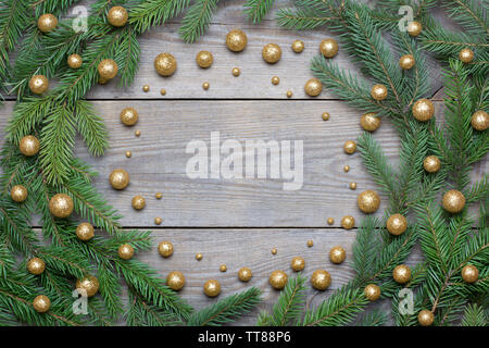 Weihnachtskarte mit Tannenbaum, Zweige und Brocade Kügelchen in einem Kreis auf Holz- Hintergrund angeordnet - text Raum Stockfoto