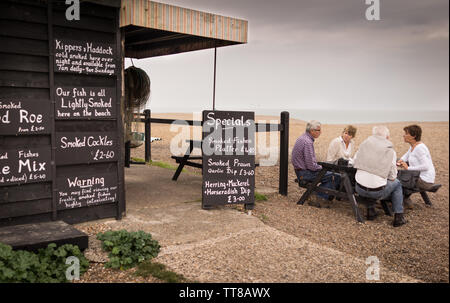 Ein Crab Shack am Strand von Aldeburgh mit Leute sitzen auf einem Picknicktisch Stockfoto