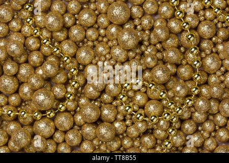 Weihnachten Hintergrund mit großen und kleinen goldenen glitter Kugeln und goldenen Perlen Kette Stockfoto
