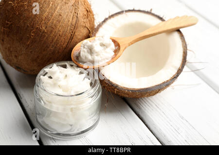 Kokosnuss mit Kokosöl in Glas auf Holz- Hintergrund Stockfoto