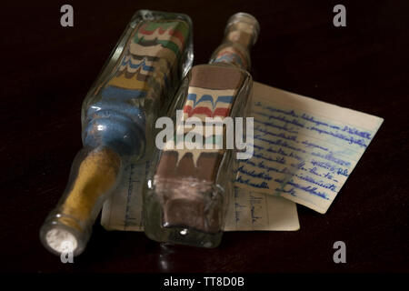 Decoratif Flaschen mit Sand und alten handgeschriebenen Buchstaben Stockfoto