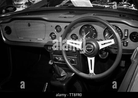 Innere Aufnahme eines klassischen Oldtimer Triumph TR6 Sport Auto Übersicht sterring Rad, Zifferblättern, Messinstrumente, Schalter und Instrumente in Schwarz und Weiß. Stockfoto