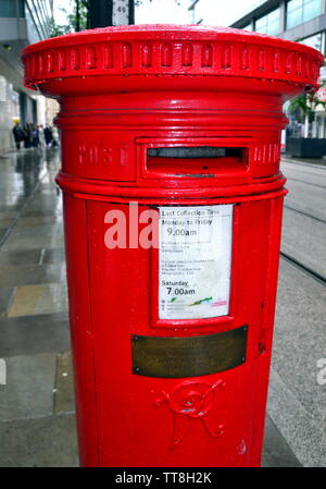 Juni 15, 2019, markiert der 23. Jahrestag der IRA-Bombe, die das Stadtzentrum von Manchester UK im Jahr 1996 verwüstet. Dieser Briefkasten auf Corporation Straße blieb stehen und trägt eine Gedenktafel, um dies zu markieren. Das messingschild trägt die Inschrift: "Dieses Postfach stehen blieb fast unbeschädigt am Juni 15, 1996, wenn dieser Bereich wurde durch eine Bombe zerstört. Das Feld wurde während der Wiederaufbau der Stadt Zentrum entfernt und wurde zu seiner ursprünglichen Aufstellungsort auf November 22 1999" zurück. Die Bombe verletzt etwa 200 Personen. Niemand hat noch nicht mit der Bepflanzung der Bombe in Rechnung gestellt. Stockfoto